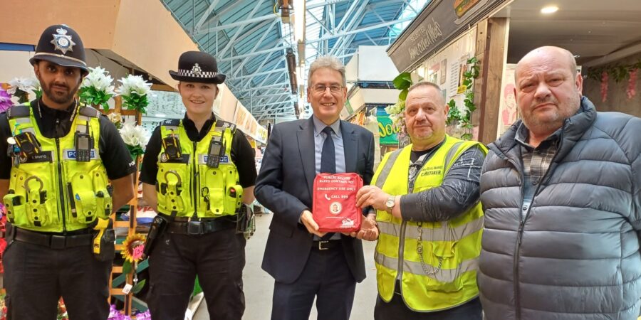 West Midlands Police and Crime Commissioner Simon Foster hands out a new bleed control kit to Brierley Hill Market caretaker Steve Bridgwater
